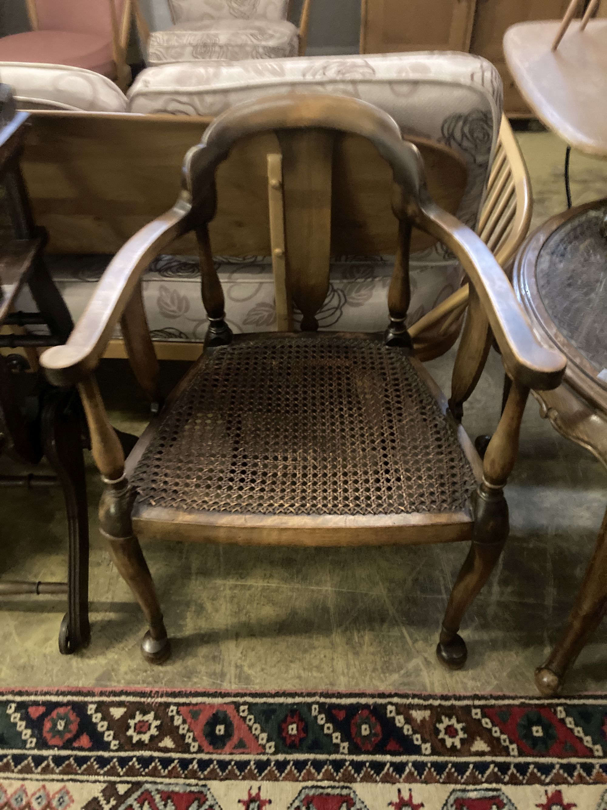 A 1920s circular caned beech occasional table, diameter 76cm, together with a pair of elbow chairs, one with a later tapestry seat